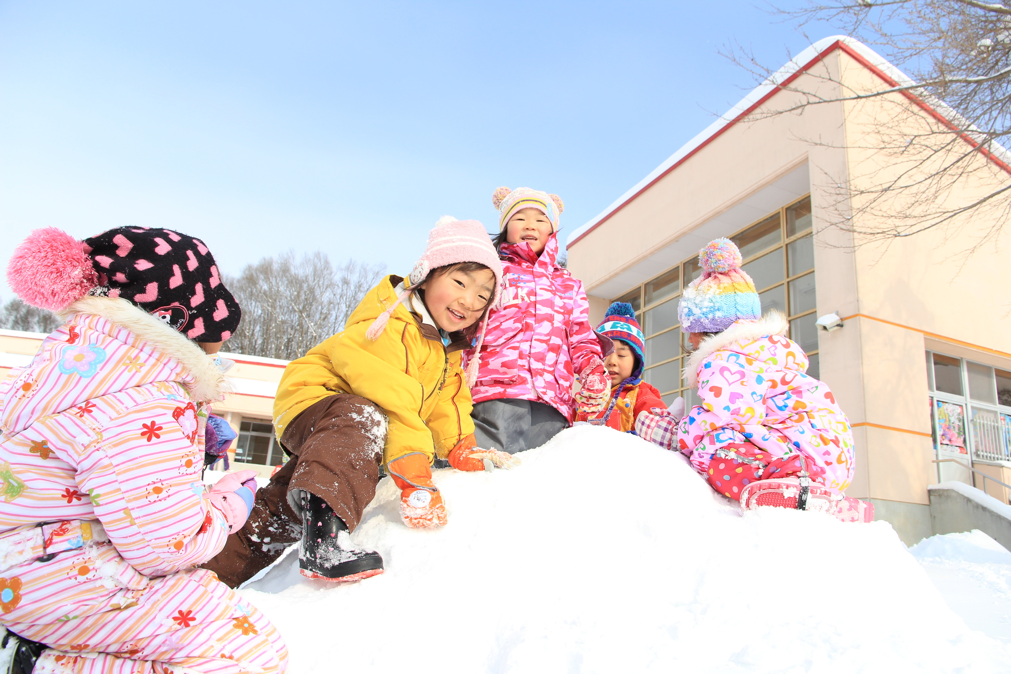 雪の上で園児が遊ぶ写真